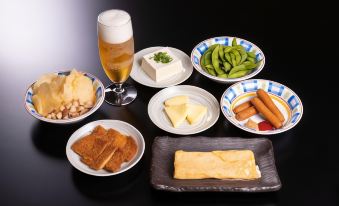 a dining table with a variety of food items , including vegetables , cheese , bread , and a glass of beer at Century Plaza Hotel