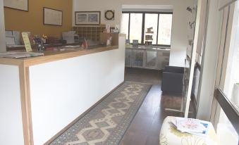 a room with a wooden floor , a white counter , and a rug on the floor at Red Cedars Motel