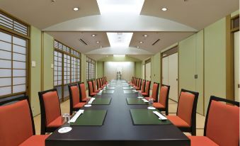 a long conference table with chairs arranged in rows , ready for a meeting or presentation at Hotel Verde