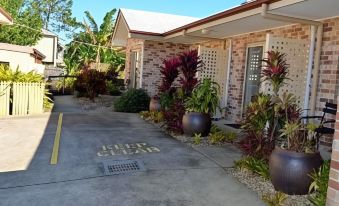 "a brick house with a sign that says "" cooper star "" and several potted plants in front of it" at Redland Bay Motel