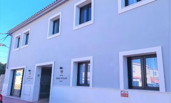 "a white building with three windows and a sign that says "" vilar blancas "" in the background" at Hotel Son Vilar