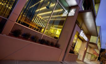 a modern building with a large window , and the exterior of the building has been illuminated by led lights at Hotel 115