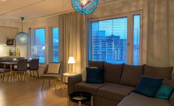 a cozy living room with a couch , chairs , and a dining table in the background at The Harbour Apartments