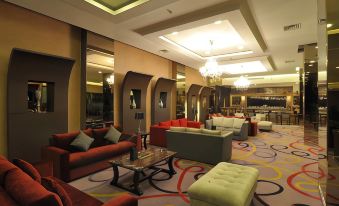 a large , well - lit living room with various couches and chairs arranged in a lounge - like setting at Hotel Horison Grand Serpong