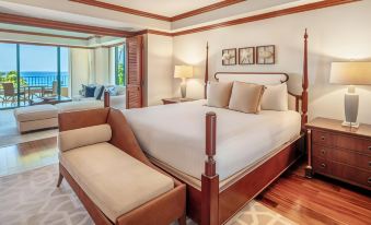 a large bed with white linens and a wooden headboard is in a room with hardwood floors at Grand Hyatt Kauai Resort and Spa