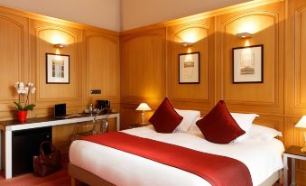 a large bed with a red blanket and white sheets is in a room with wooden walls at Hotel de Bourgtheroulde, Autograph Collection