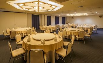 a large , empty banquet hall with multiple round tables and chairs set up for a formal event at Airline Hotel
