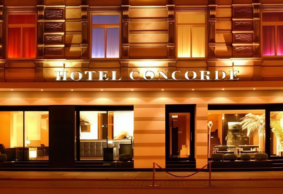 "a hotel entrance with a sign that reads "" hotel concorde "" prominently displayed on the building" at Hotel Concorde