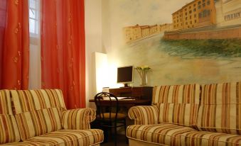a living room with two striped couches and a painting of a city on the wall at Hotel Leonardo
