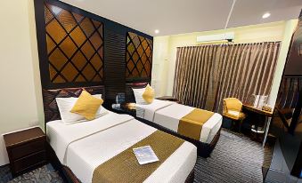 a hotel room with two beds , a desk , and a window , all decorated in a modern style at Richmond Hotel Sylhet