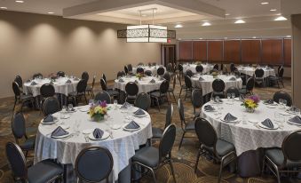 a large banquet hall with multiple round tables set up for a formal event , possibly a wedding reception at DoubleTree by Hilton Hotel Murfreesboro