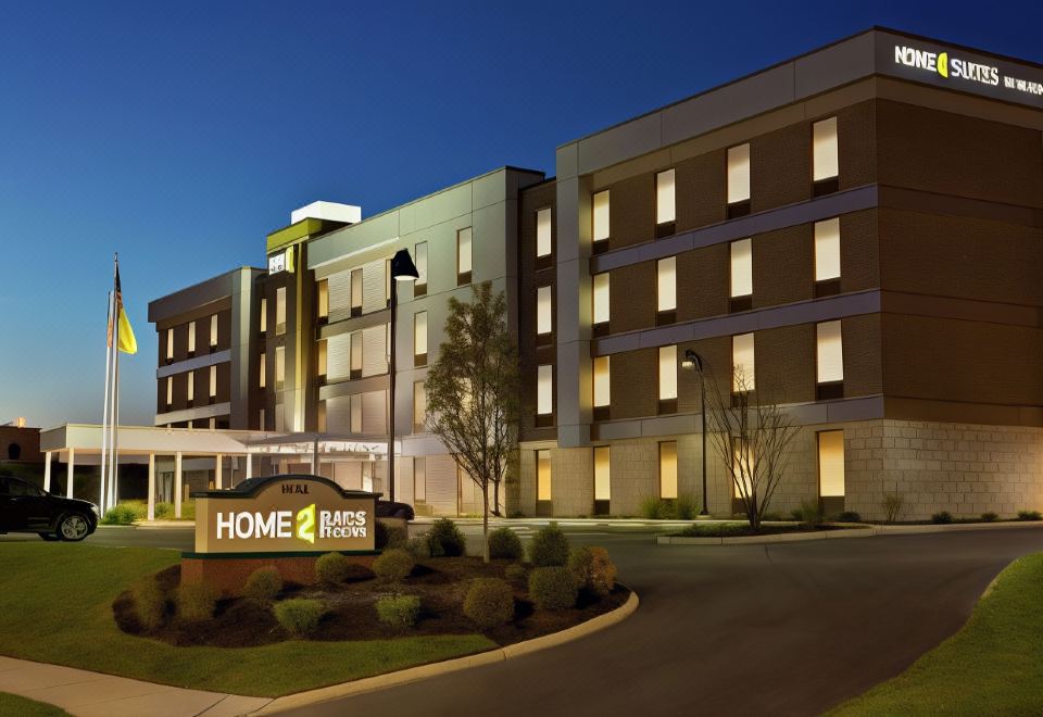 "a large , modern hotel building with the name "" home 2 suites by hilton "" prominently displayed on its front" at Home2 Suites by Hilton Lawrenceville Atlanta Sugarloaf