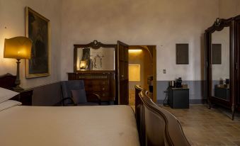 a bedroom with a bed , chairs , and a desk in front of an open door at Castello di Semivicoli