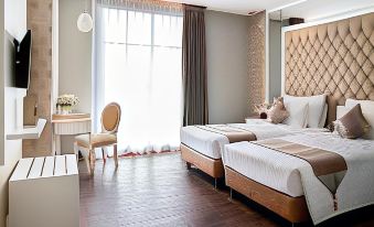 a hotel room with two beds , one on the left and one on the right side of the room at Savero Hotel Depok