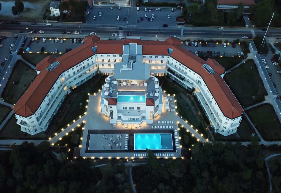 an aerial view of a large hotel with a pool and red - tiled roof at night at Toscana Charme Resort