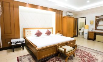 a large bedroom with a king - sized bed , a bathroom , and a door leading to a hallway at Hotel Cianjur Cipanas