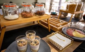 a dining table with a variety of food items and drinks , including jars of nuts and desserts at Morwell Motel