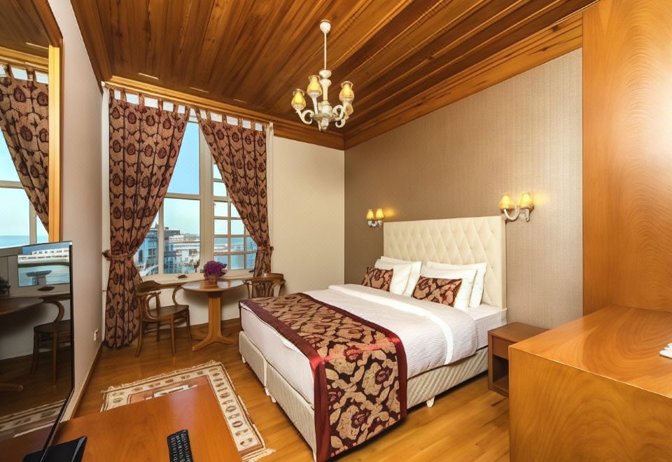 bedroom with large windows and a wooden ceiling at Mom Hotel