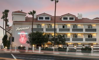 "a hotel building with a large neon sign that says "" hermosa "" in front of it" at Hotel Hermosa