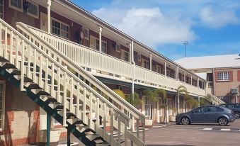 a row of apartment buildings with balconies and stairs leading up to one of them at Motel Goolwa
