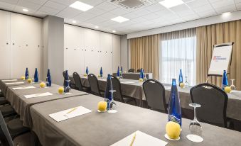 a conference room set up for a meeting , with chairs arranged in rows and a whiteboard on the wall at Hilton Garden Inn Malaga