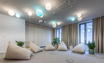 a large room with a white floor and several bean bag chairs arranged in front of a window at Hilton Garden Inn Mannheim