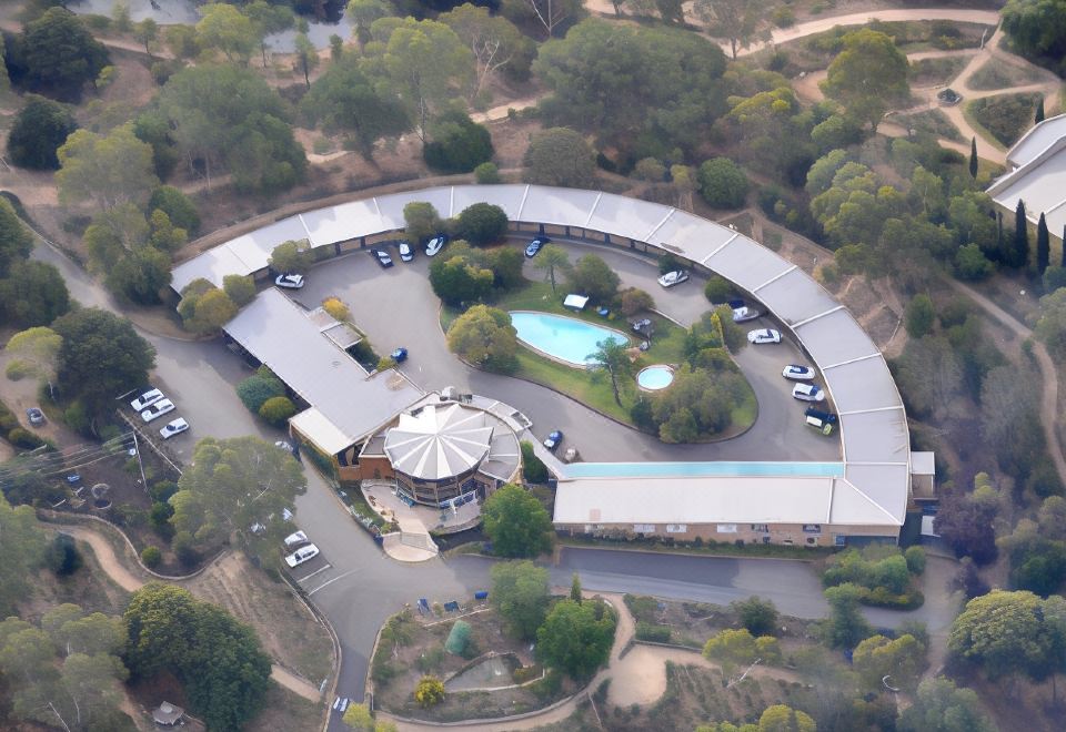 an aerial view of a building with a large circular driveway and a pool in the foreground at Lyndoch Hill