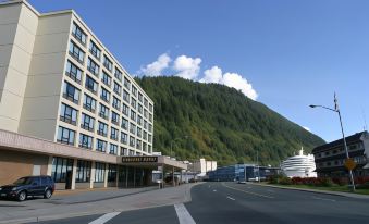 "a large building with a sign that says "" hotel "" is located on a street in front of a mountainous landscape" at Four Points by Sheraton Juneau