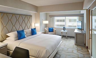 a hotel room with a king - sized bed , a desk , and a tv . the room has a modern design and features a large window at The Kingsley Bloomfield Hills - a DoubleTree by Hilton