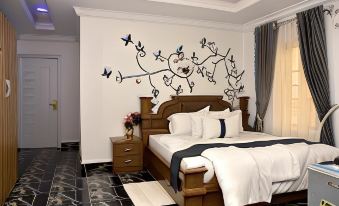 a modern bedroom with a wooden bed , white bedding , and a black and white patterned wall at Mountain Top Lodge Hotel