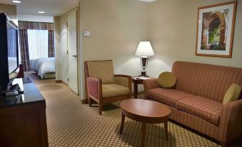 a living room with a couch , chair , and coffee table in front of a bed at Hilton Garden Inn Casper