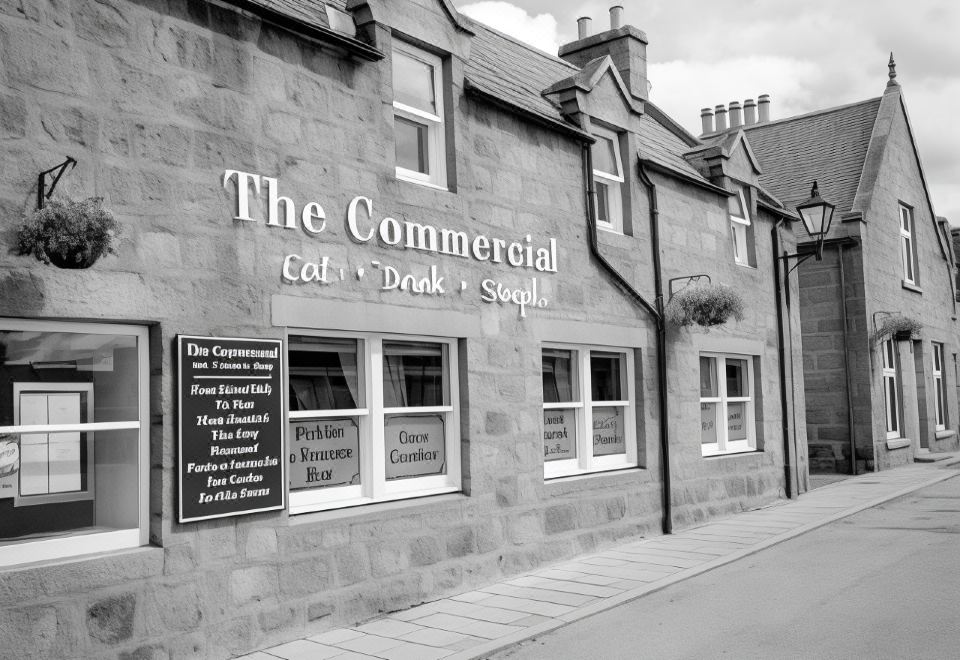 a black and white photo of the exterior of the commercial cafe , a restaurant in the city at The Commercial Hotel