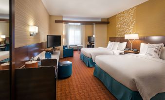 a modern hotel room with two beds , a desk , and a tv , decorated in neutral colors at Fairfield Inn & Suites by Marriott Tustin Orange County
