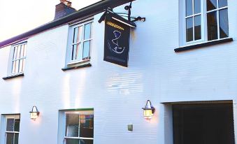 "a building with a sign that reads "" mark 's fish & chips "" hanging on the side of the building" at The Anchor Inn