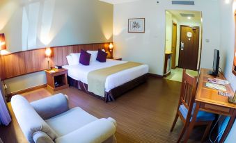 a hotel room with a large bed , couch , dining table , and desk , all set against a wooden wall at StarLodge