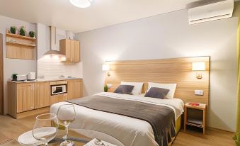 a modern hotel room with a bed , nightstands , and lamps , as well as a dining area with a table and chairs at Gostinic