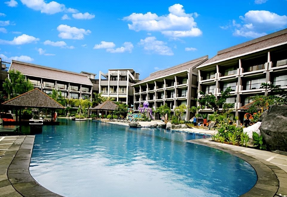 a resort with a large pool surrounded by multiple buildings , including an apartment building and a hotel at Sahid Bela Ternate