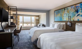 a hotel room with two beds , one on the left and one on the right side of the room at Marriott Dallas Las Colinas