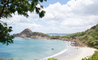 a serene beach scene with a group of people enjoying their time in the water and on the sand at Aqua Nicaragua