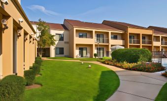 a large apartment complex with multiple buildings and a grassy lawn in front of it at Courtyard Richmond West