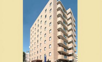 a large , beige - colored building with multiple levels and balconies is situated on a street corner at Hamamatsu Hotel