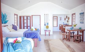 a bedroom with a bed and blue blanket , next to a kitchen area with wooden doors and furniture at Le Life Resort