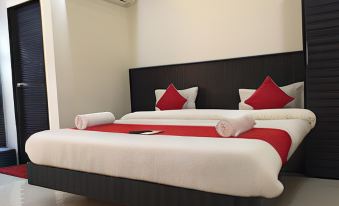 a bed with a black headboard and white sheets is adorned with red and white pillows at Holiday Inn