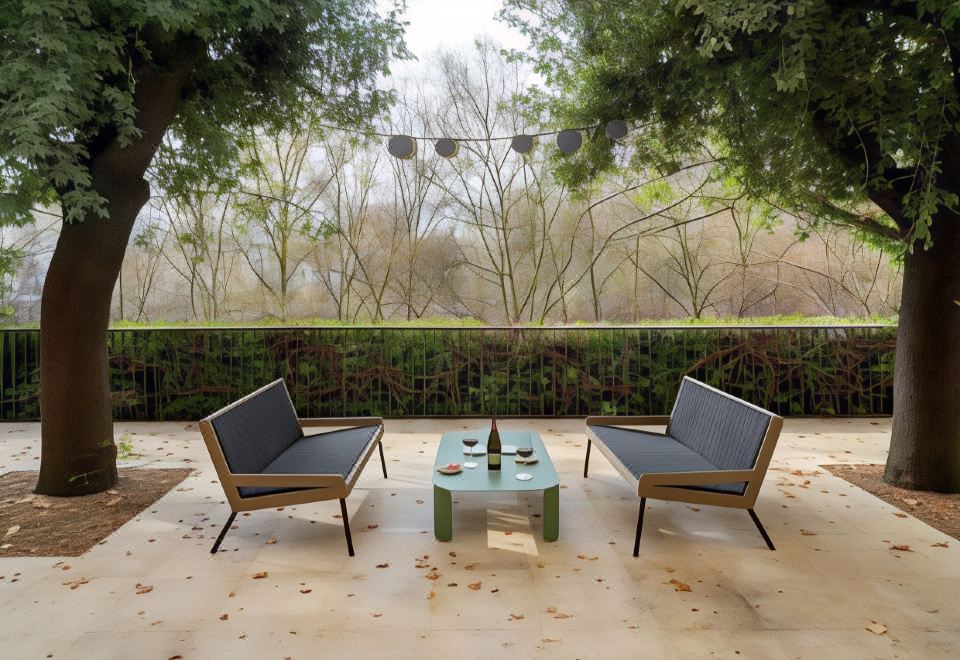 a patio area with two couches , a coffee table , and a view of trees in the background at Parador de Leon - San Marcos