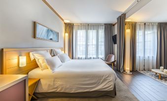 a large bed with white sheets and pillows is in a room with wooden furniture at Hotel le Morgane
