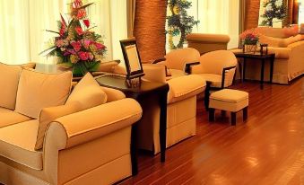 a well - decorated living room with wooden flooring , two yellow armchairs , and a large potted plant at Hotel Hakuba