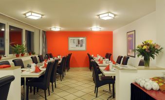 a dining room with several tables and chairs arranged for a group of people to enjoy a meal at Bellevue Hotel
