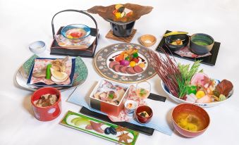 a dining table with a variety of dishes and utensils , including bowls , forks , knives , spoons , and chopsticks at Furano la Terre