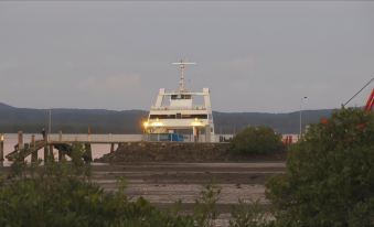 a white boat is docked at a pier with a body of water in the background at Redland Bay Motel