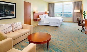 a hotel room with a large bed , a couch , a chair , and a dining table at The Westin Chicago North Shore